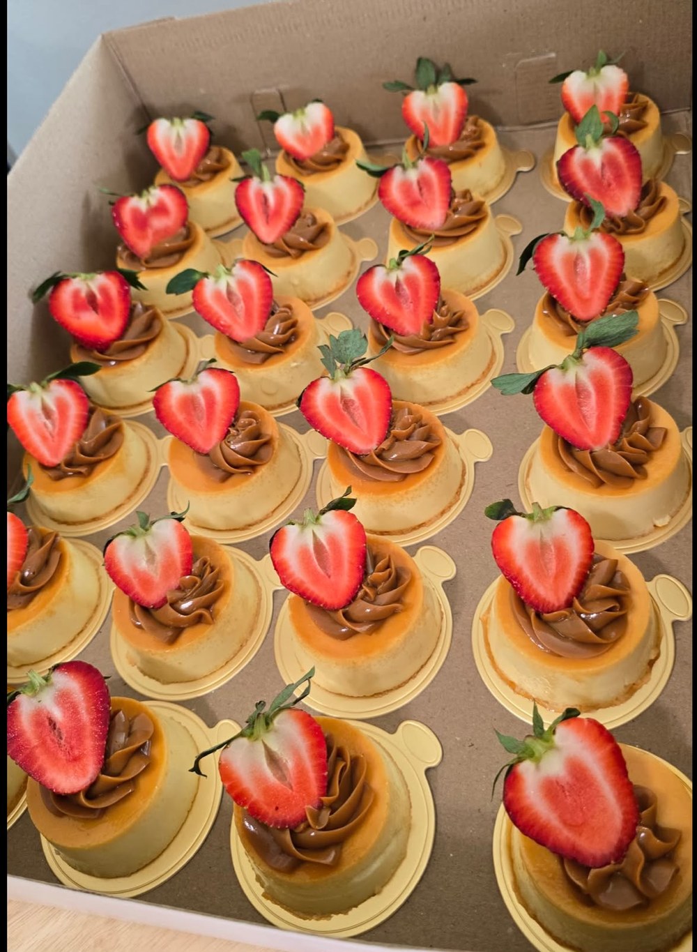 Flanes individuales con dulce de leche y media fresa en forma de corazón